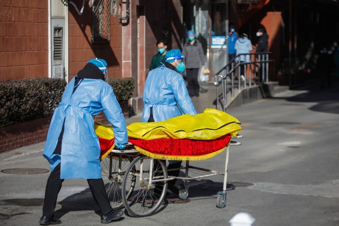 Volunteer health workers push a stretcher in front of the fever clinic at Chaoyang Hospital in Beijing on Wednesday. Medical staff from outside Beijing are being sent to the capital to help cope with the number of hospital admissions. Photo: EPA-EFE