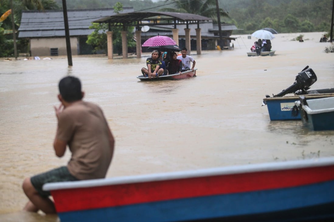 People use boats to travel through a flooded area in Kuala Terengganu, Malaysia, on Wednesday. Photo: EPA-EFE