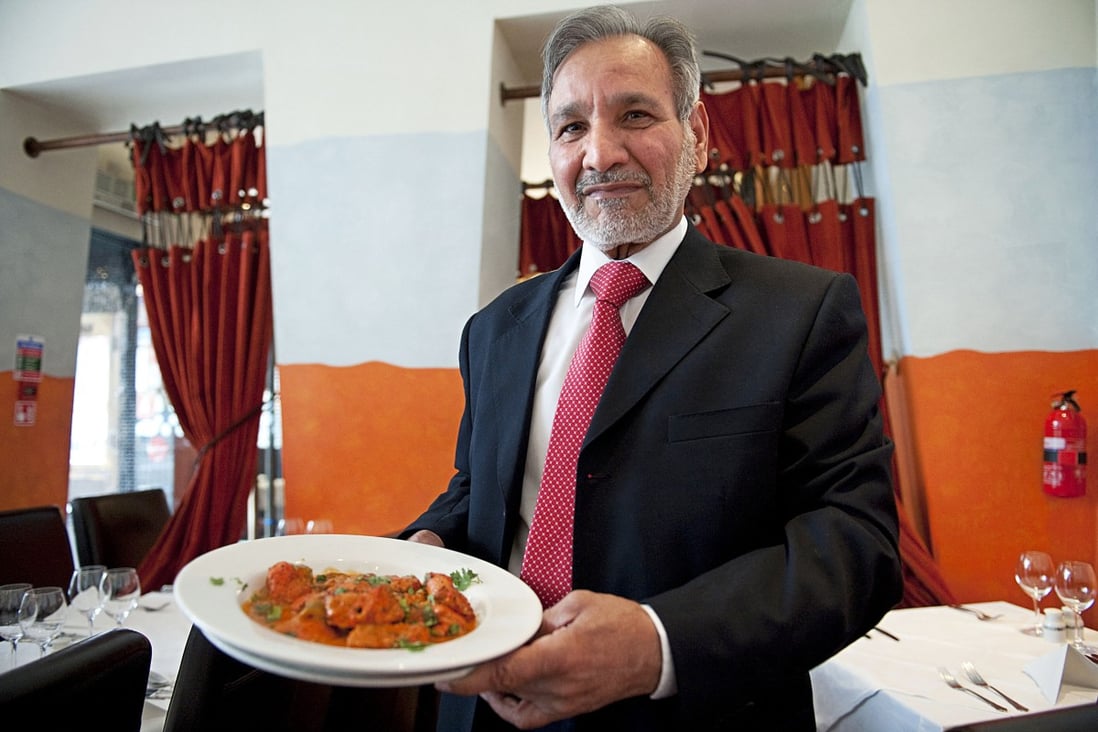 Ahmed Aslam Ali, the owner of the Shish Mahal restaurant in Glasgow, holds a plate of chicken tikka masala in his Shish Mahal restaurant in Glasgow, where he claims to have come up with the dish in the 1970s. Photo: AFP