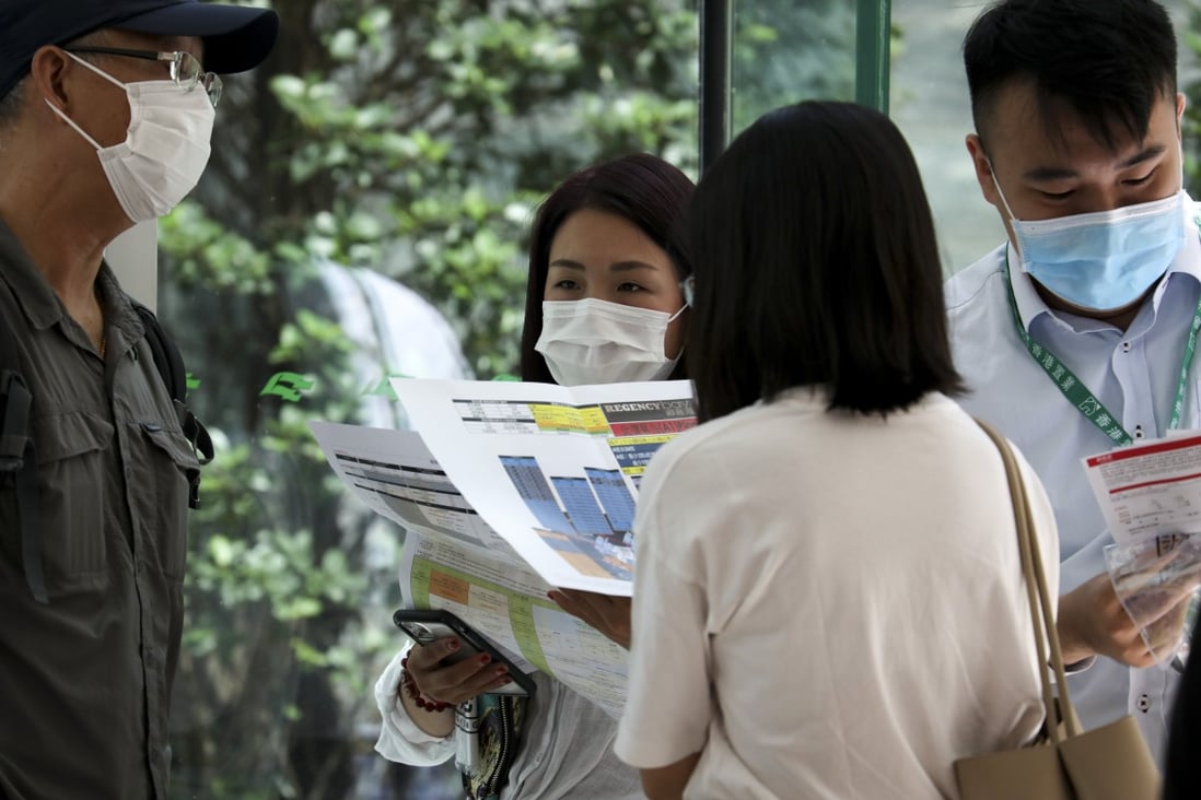 Potential home buyers line up at a sales office in International Commerce Centre (ICC) in July 2020 to buy 108 units at the Regency Bay development by Sun Hung Kai Properties in Tuen Mun. Photo: Xiaomei Chen