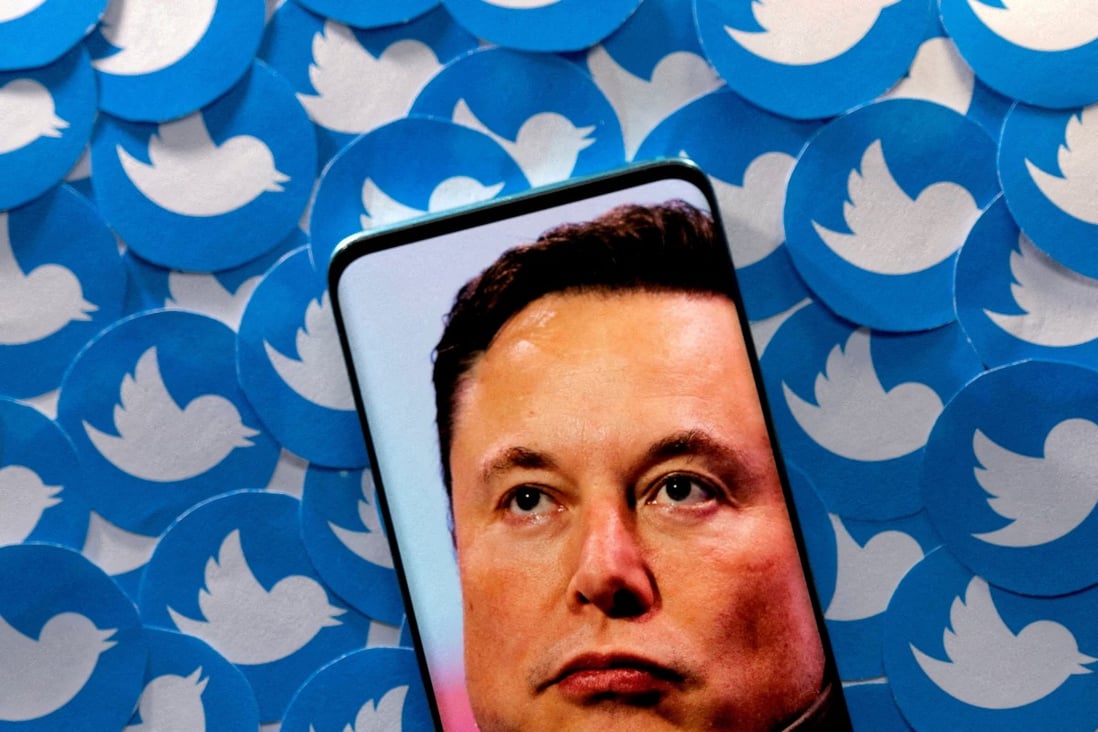 An image of Elon Musk is seen on a smartphone placed on printed Twitter logos. The billionaire took Twitter private in a US$44 billion deal in October. Photo: Reuters