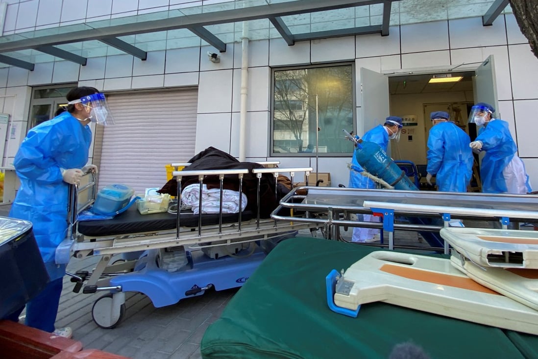 Medical workers are seen outside a fever clinic at a hospital in Beijing on Friday as the city battles a wave of cases. Photo: Reuters