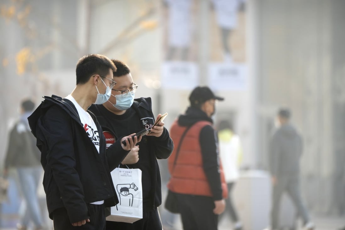 People look at their smartphones in Wangfujing shopping district in Beijing, on November 19. Photo: AP