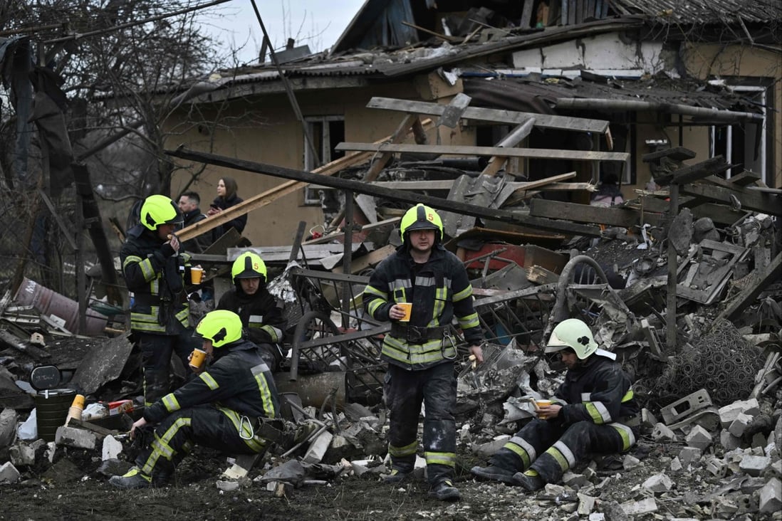 Rescuers rest after clearing debris of homes destroyed by a missile attack in the outskirts of Kyiv, on Thursday. Photo: AFP