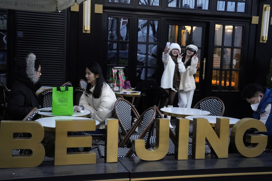 People pose for selfies outside a popular bakery in Beijing on December 28. China says it will resume issuing passports for tourism in another big step away from pandemic controls that isolated the country for almost three years, setting up a potential flood of Chinese going abroad for next month’s Lunar New Year holiday. Photo: AP