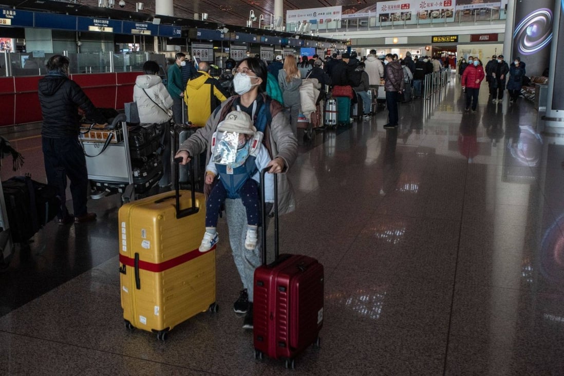 A woman pushes luggage near a check-in counter at Beijing Capital International Airport on Friday. Photo: Bloomberg