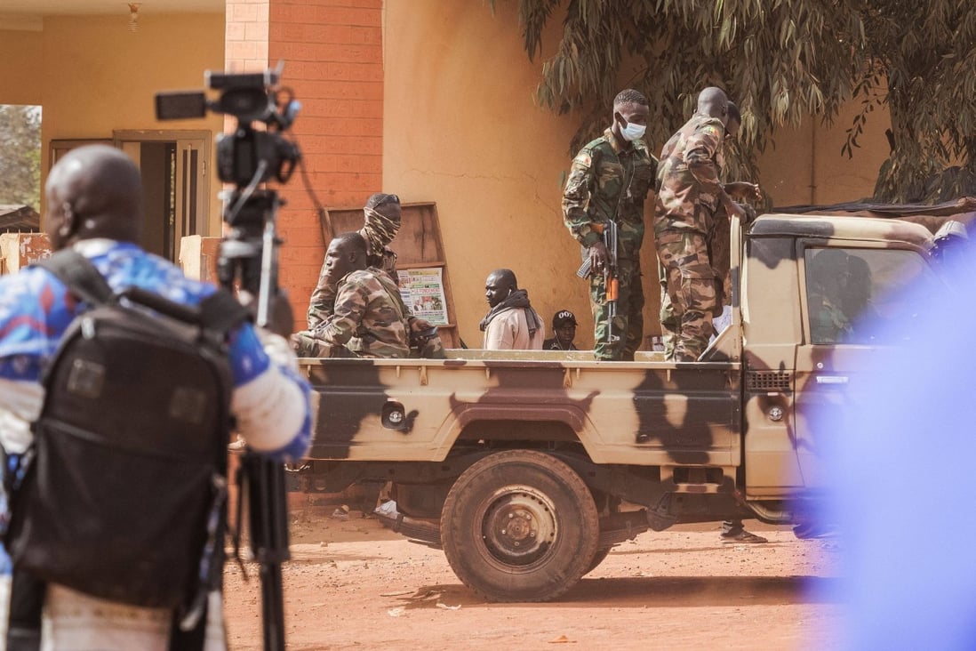 Journalists and military personnel wait outside the Court of Appeal in Bamako, as the trial of the 46 Ivorian soldiers arrested in Mali takes place on Friday. Photo: AFP
