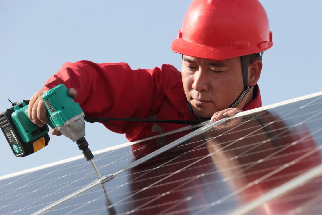 A PetroChina worker installs photovoltaic panels along the Tarim desert road in northwest China’s Xinjiang Uygur autonomous region. Photo: Xinhua