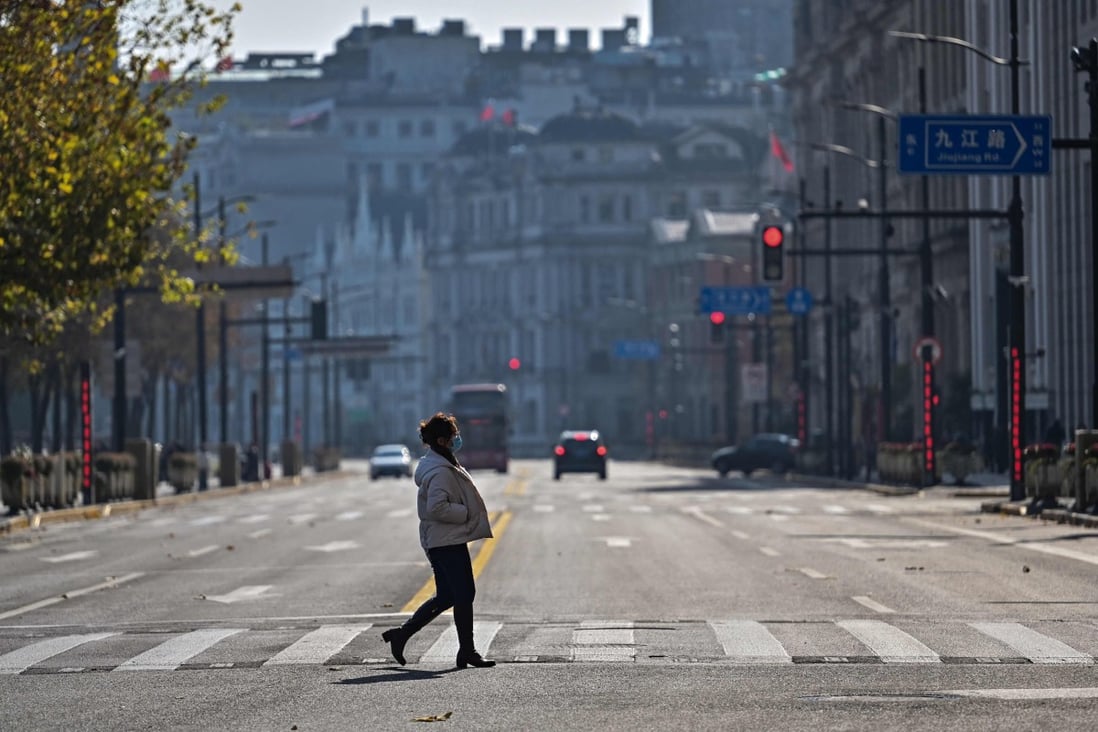 A woman crosses a street on the Bund in the Huangpu district in Shanghai on December 21. Photo: AFP
