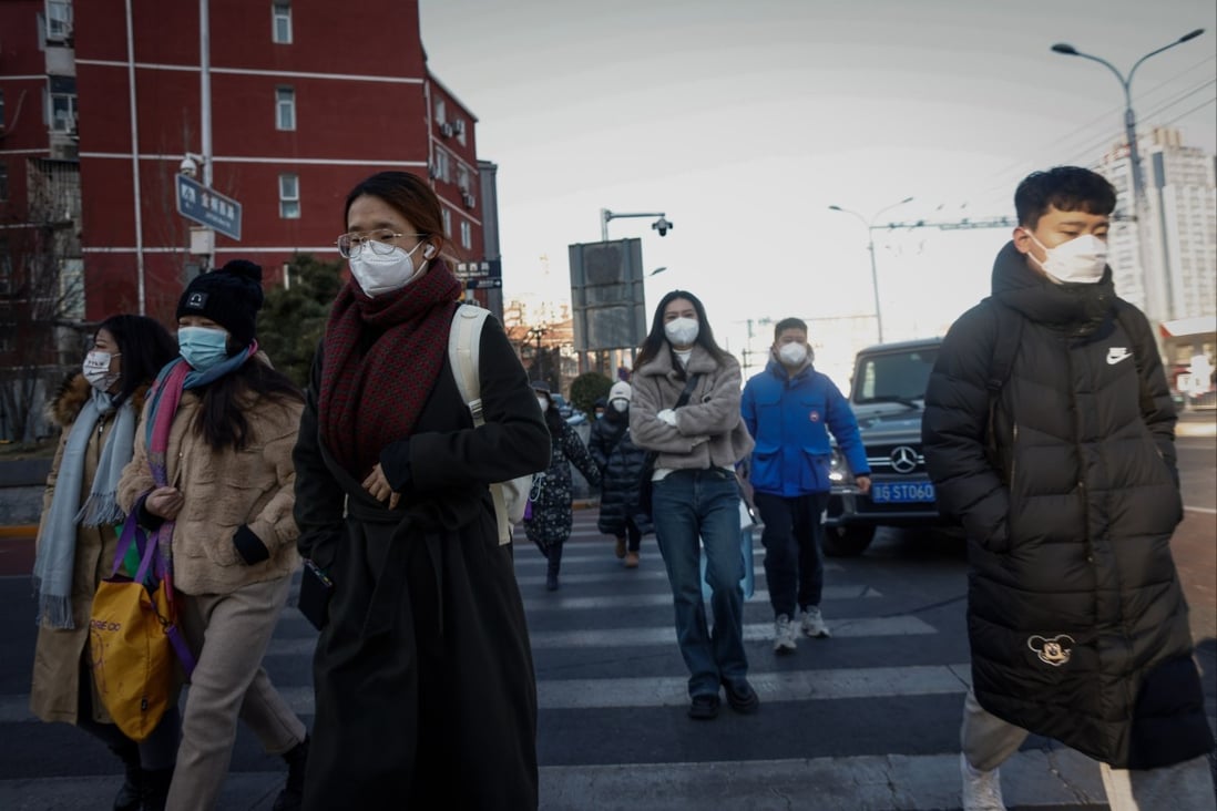 People wearing face masks cross a road in Beijing. Scientists have warned that China will face multiple waves of Covid-19 infections as the Omicron variant mutates to spread faster and evade immunity. Photo: EPA-EFE