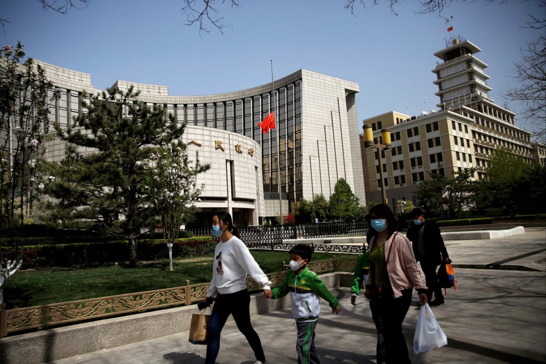People walk past the headquarters of the People’s Bank of China in Beijing. Photo: Reuters