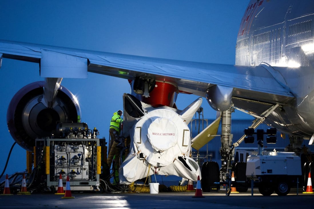 Technicians work on Virgin Orbit’s rocket, attached to the wing of a Boeing 747. Photo: Reuters