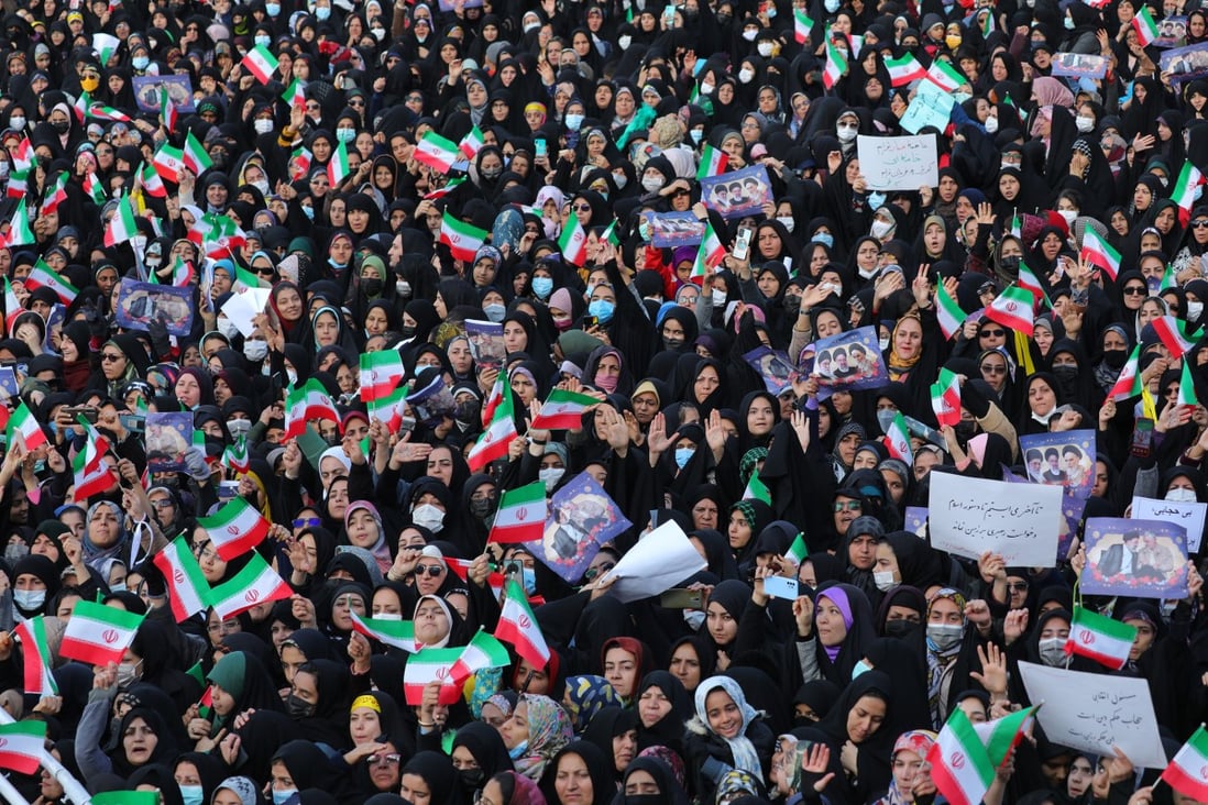 People wave Iranian flags during a speech by Iranian President Ebrahim Raisi in Yazd city. Photo: Iranian Presidency/dpa