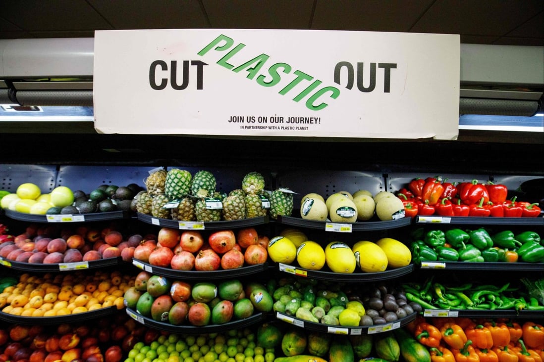 A sign promoting plastic free packaging is seen above a display of loose fresh fruit at Budgens supermarket in north London. Photo: AFP