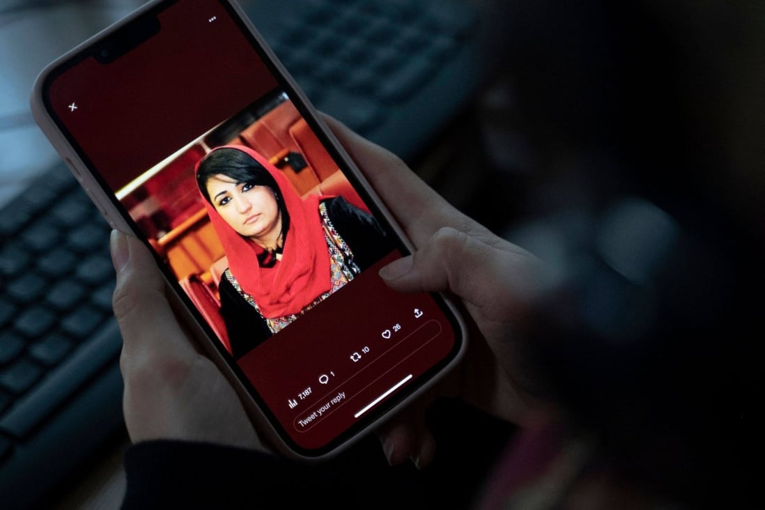 A woman looks at a photo of former Afghan lawmaker Mursal Nabizada on her mobile phone. Nabizada was shot dead by gunmen at her house in Kabul. Photo: AFP