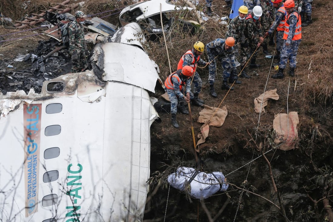 Rescuers recover the body of a victim from the site of the plane crash in Pokhara, Nepal, on Monday. Photo: Reuters
