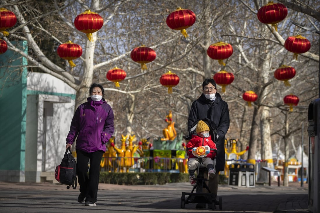 A man pushes a child in a stroller at a public park in Beijing. Photo: AP 