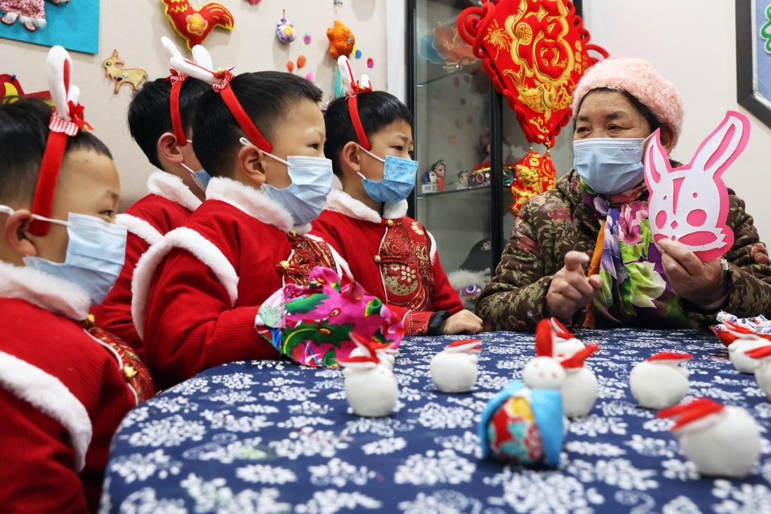 Children learn about culture from a woman in preparation for the Year of the Rabbit in Huzhou, China. Lunar New Year celebrations often include the wearing of red-coloured clothing – but some traditions are rarely observed any more. Photo: Getty Images