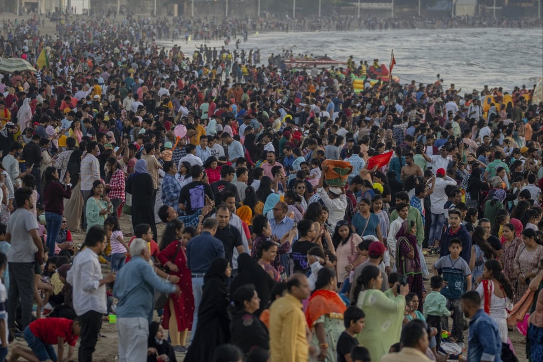People crowd a beach in Mumbai on December 31 to watch the last sunset of 2022. India’s population stood at an estimated 1.417 billion as of the end of last year. Photo: AP
