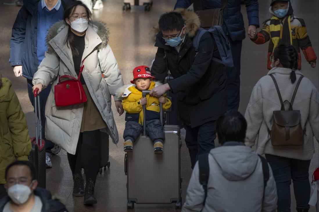 A man pushes a child on a suitcase at Beijing West railway station on January 18. A population that is slowly shrinking will pose new challenges for China’s leaders. Photo: AP 