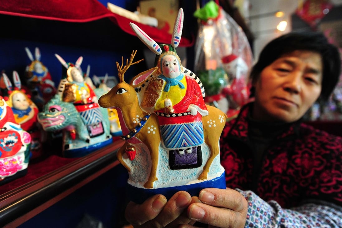A woman displays a rabbit figurines in a her toy shop near the Confucius Temple in Beijing. Photo: AFP