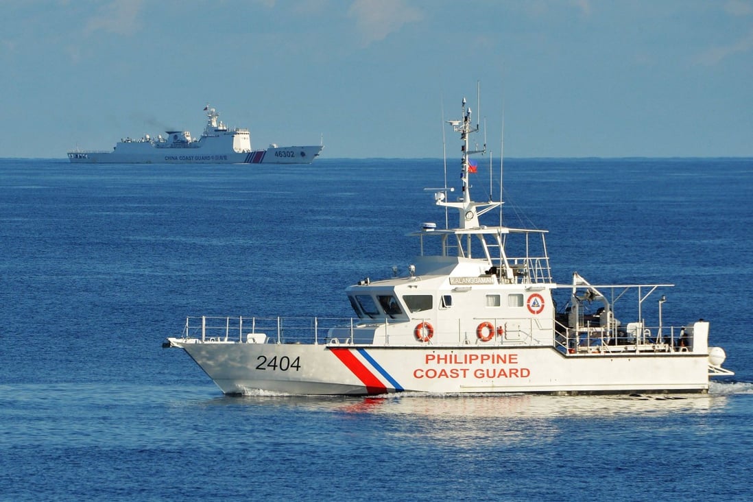 A Philippines coastguard ship sails past a Chinese coastguard vessel near Scarborough Shoal in the South China Sea. Photo: AFP