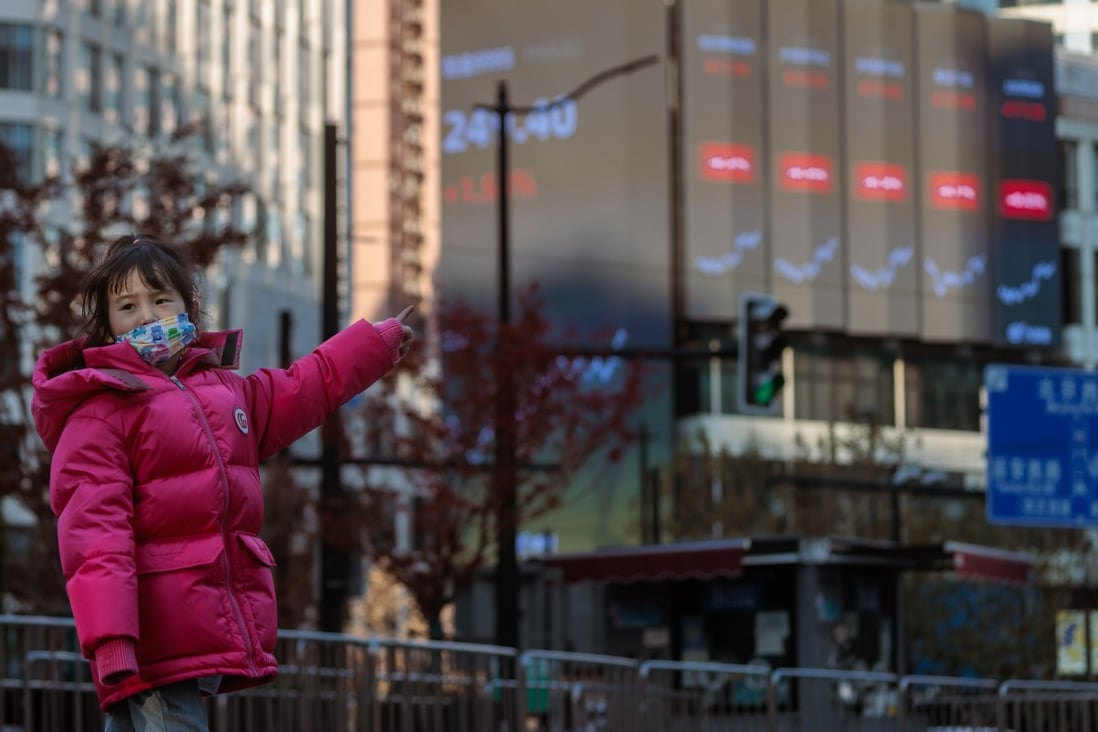 A child points to a large screen showing stock exchange data, in Shanghai, on January 3. Now appears the right time to get back into the China market. Photo: EPA-EFE