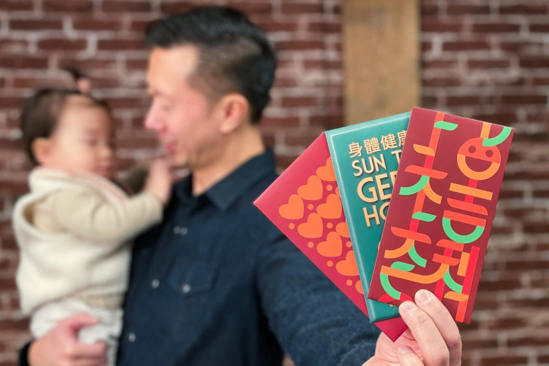 Chinese-Canadian Kevin Li holds up three Mission: Red Pocket envelopes and his daughter Ava in Vancouver. He asked three designers to make Lunar New Year greetings fun and easy to learn through modern lai see designs. Photo: Kevin Li