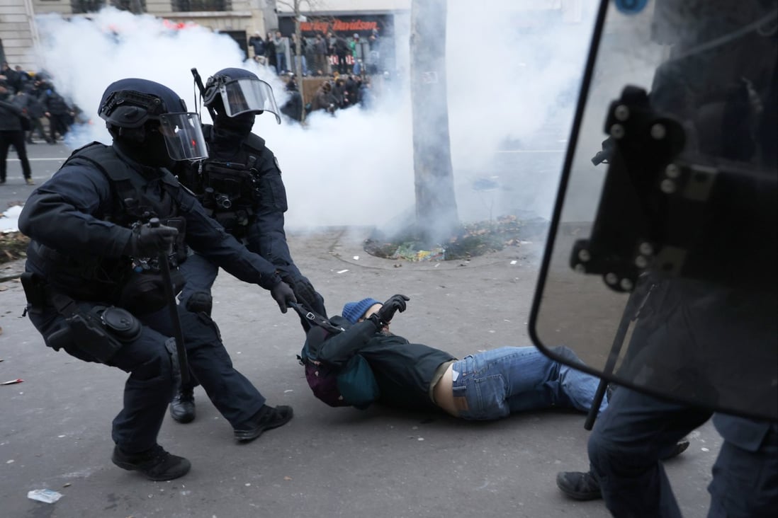 Riot police officers grab a protester during a demonstration against pension changes in Paris, France on Thursday. Photo: AP 