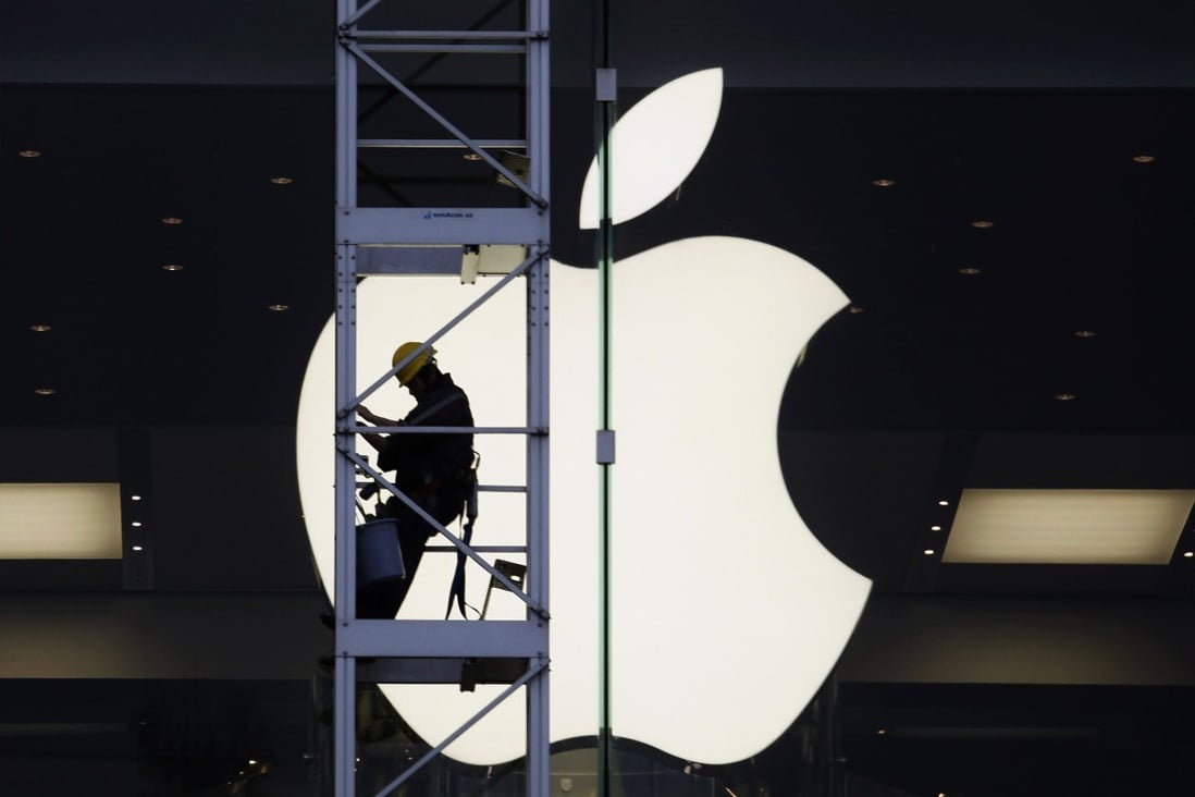 A worker climbs on scaffolding in front of the Apple logo at one of the US technology company’s stores in Hong Kong. Photo: Reuters
