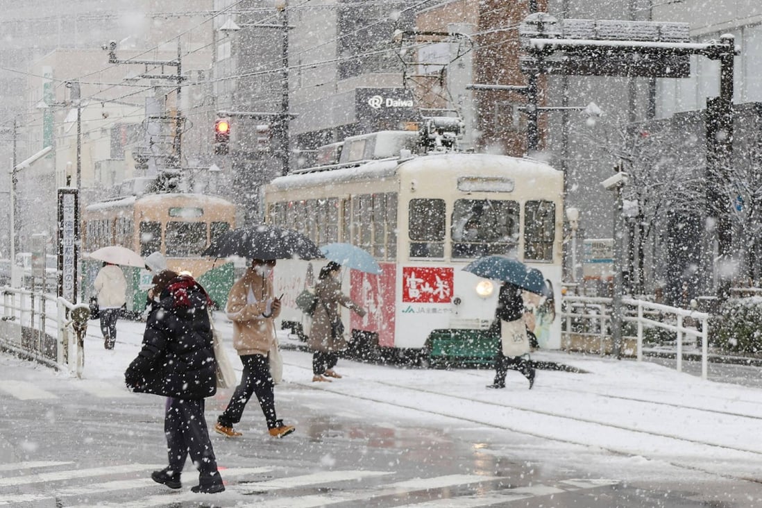 Pedestrians in the city of Toyama on the central-western coast of Japan brave a snowstorm. Photo: AFP