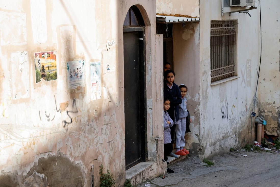 Palestinian children look out of their homes following an Israeli raid in Jenin. Photo: Reuters