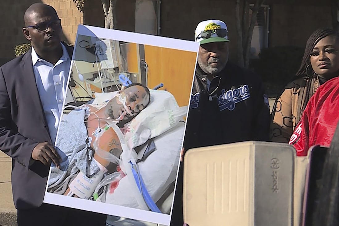 Tyre Nichols’ stepfather Rodney Wells (centre) stands next to a photo of Nichols in the hospital after his arrest during a protest in Memphis, Tennessee on January 14. Photo: WREG via AP