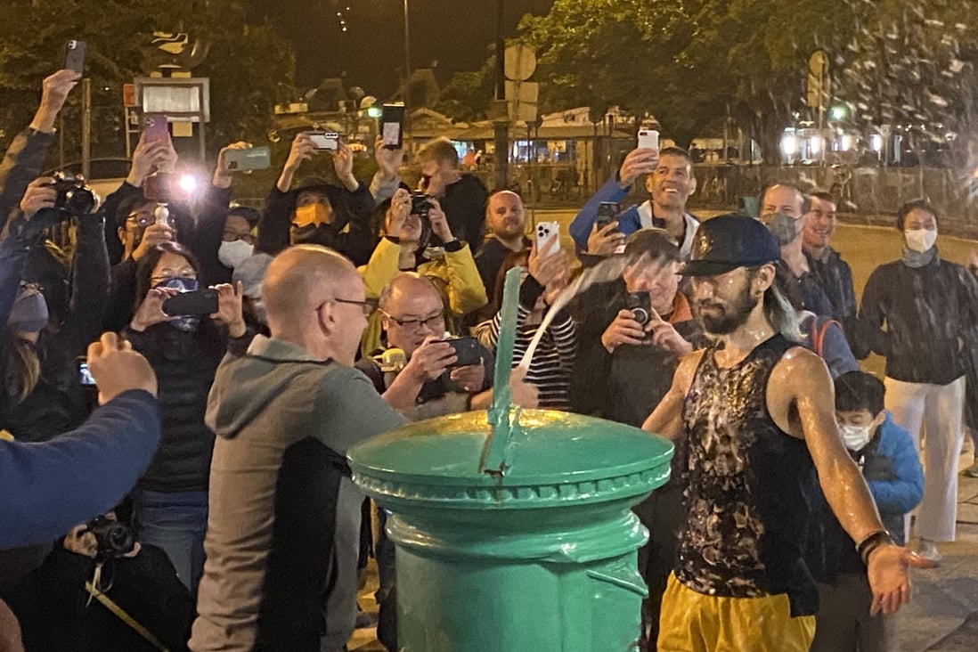 Tomokazu Ihara is sprayed with champagne after arriving first at the green postbox in Mui Wo, the finishing point of the 298km Hong Kong Four Trails Ultra Challenge. Photo: Josephine Ma