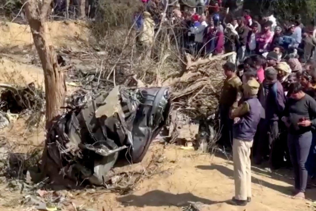 People gather around the debris of a crashed aircraft in Bharatpur, Rajasthan, India. Photo: Reuters