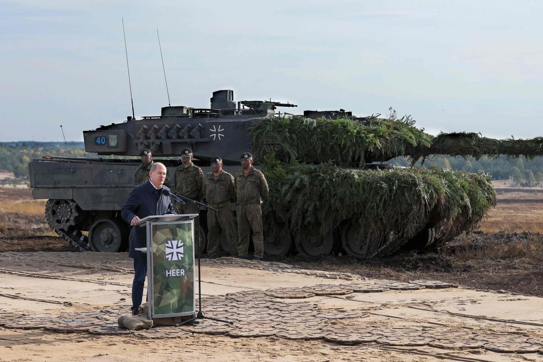 German Chancellor Olaf Scholz speaks next to a Leopard 2 battle tank of the German armed forces while visiting troops at a military ground in Ostenholz, northern Germany, on October 17, 2022. Germany on January 25 approved the delivery of Leopard 2 tanks to Ukraine, after weeks of pressure from Kyiv and many allies. Photo: AFP