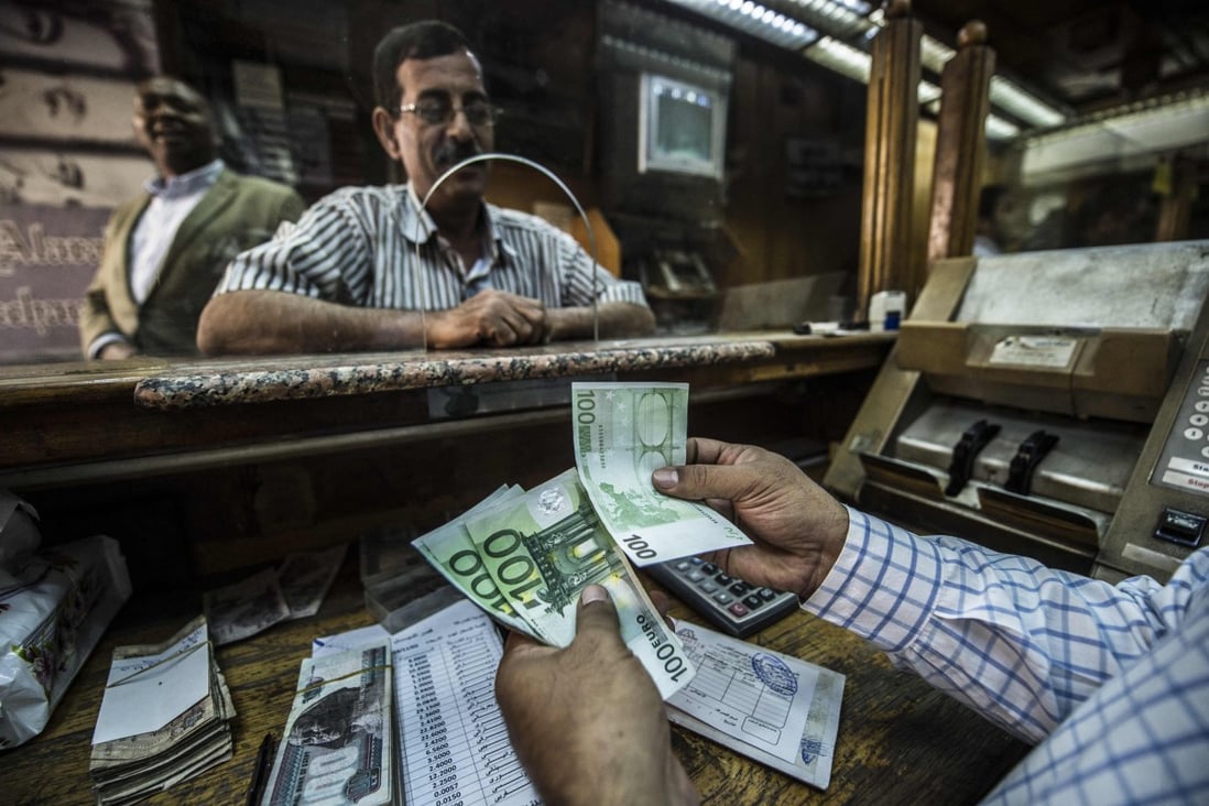 An employee counts banknotes at currency exchange in Cairo. The Egyptian pound has lost half its value against the US dollar since March, following a devaluation demanded as part of a US$3 billion IMF loan agreement. Photo: AFP