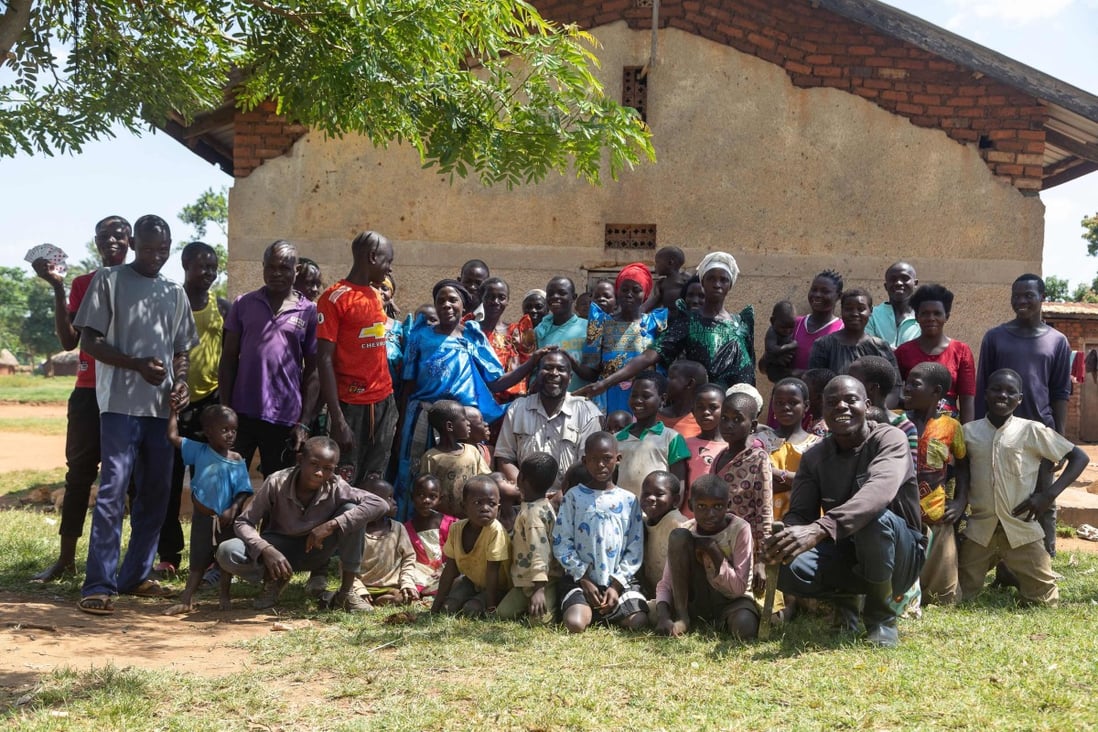 Musa Hasahya poses with some of his wives, children and grandchildren outside their family home in Butaleja district in Eastern Uganda. Photo: AFP