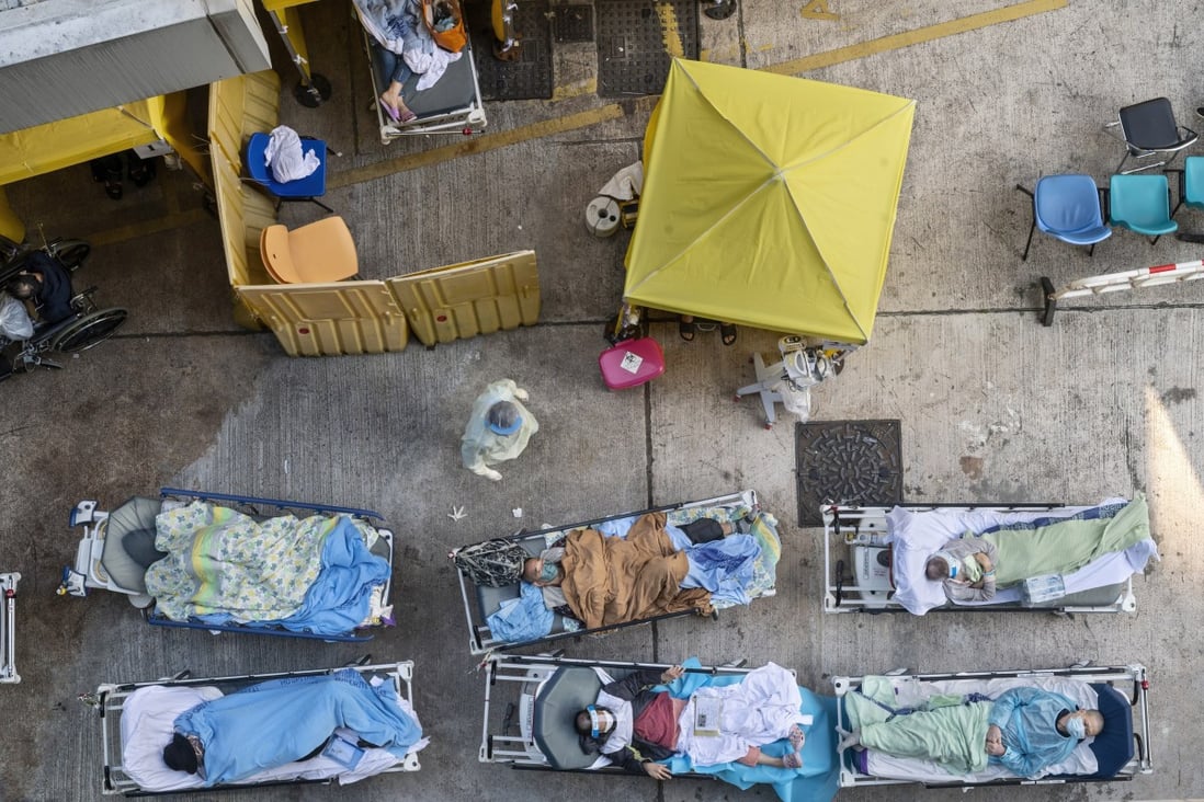 Patients showing Covid-19 symptoms lie on beds outside the Accident and Emergency Department at Caritas Medical Centre in Hong Kong on February 15, 2022. Photo: EPA-EFE
