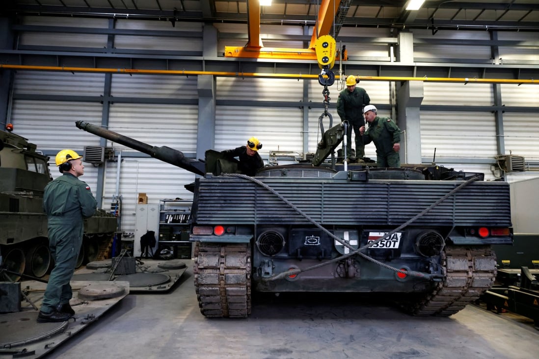 A Polish army instructor wearing a white helmet talks to Polish soldiers during a Leopard 2 tank repair training in Swietoszow, Poland on Tuesday. Photo: Reuters 