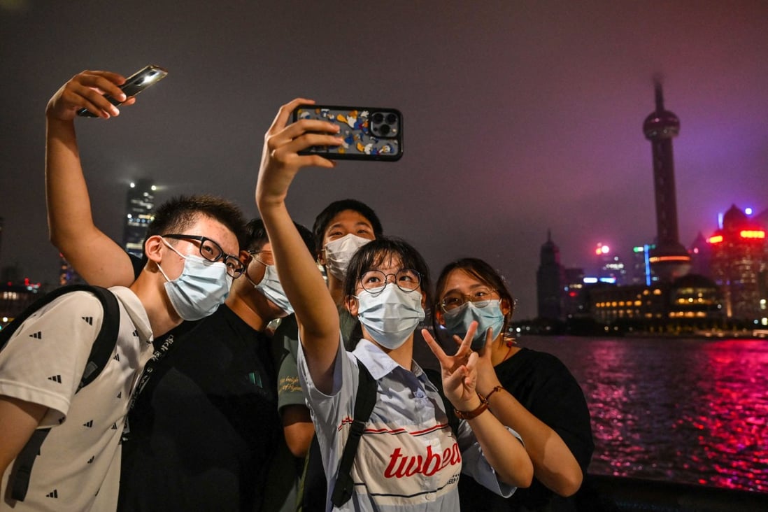 Young people pose for a selfie on the Bund promenade in Shanghai on August 23, 2022. Photo: AFP