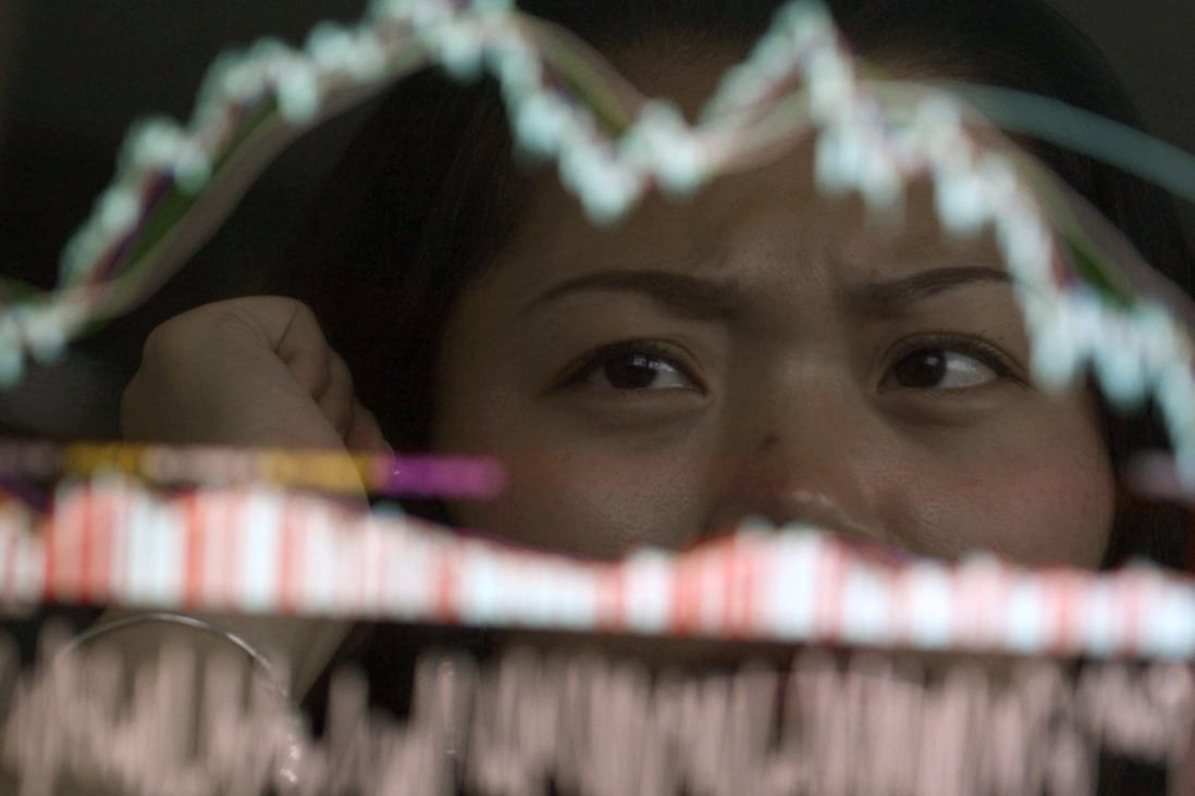 An investor is reflected on an electronic screen showing stock information at a brokerage in China. Photo: Reuters
