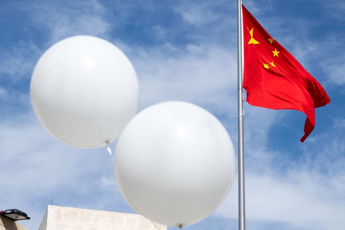 Two white balloons float near the Chinese flag as American activist Reverend Patrick Mahoney protests against the Chinese government outside the Chinese embassy in Washington on February 15 after a Chinese “balloon” was shot down over the US last week. Photo: AFP