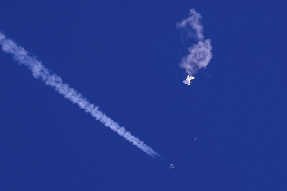 A fighter jet flies past the remnants of a large balloon after it was shot down above the Atlantic Ocean, just off the coast of South Carolina on February 4. Photo: Chad Fish via AP