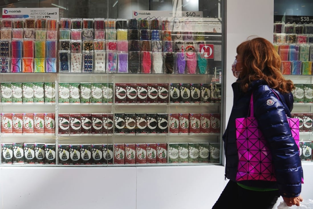 Hong Kong pharmacies ready to slash mask prices ahead of possible mandate lifting 5 A shopper in Causeway Bay walks past a store selling masks. Photo: Sam Tsang