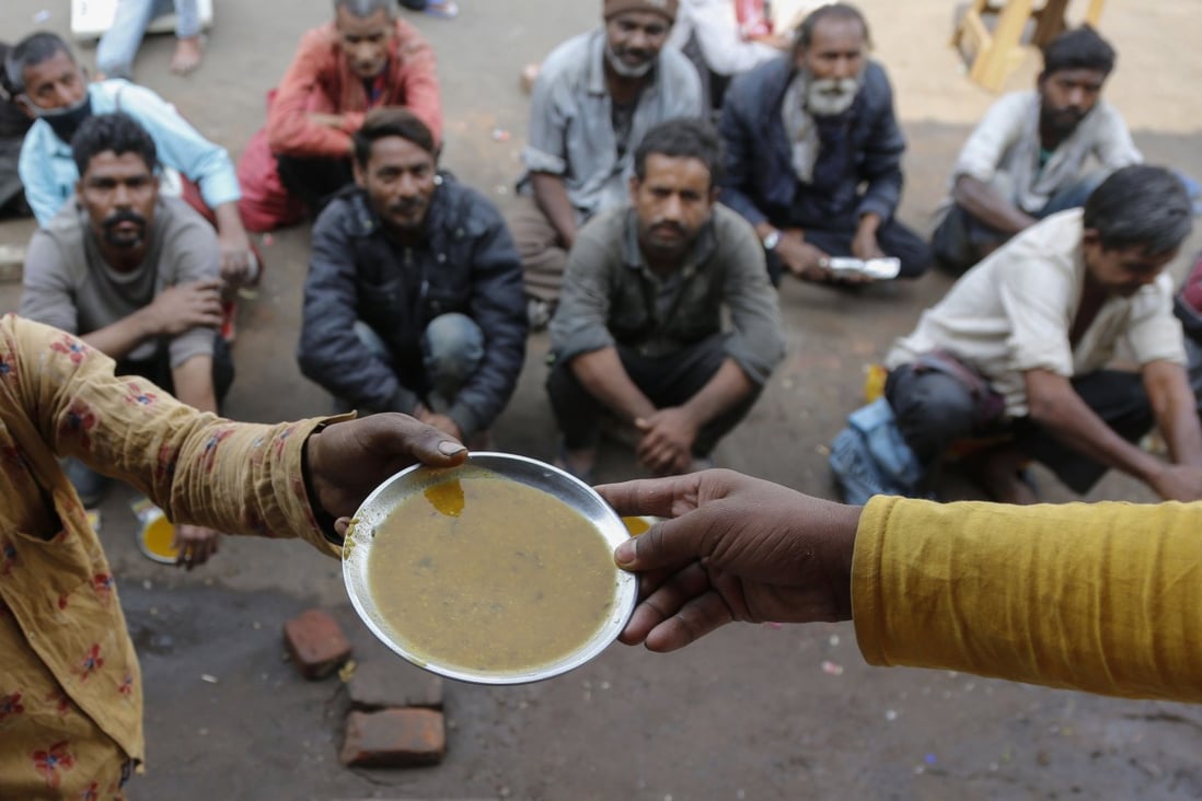 People wait for free food outside an eatery in Ahmedabad, India, on January 20, 2021. While globalisation has benefited a handful of countries, it has exacerbated the inequality and marginalisation of poorer regions of the world. Photo: AP