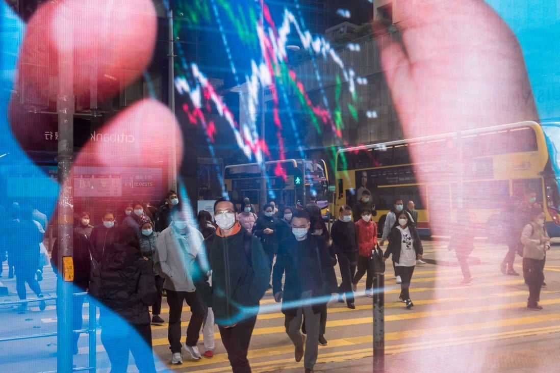 Pedestrians are reflected in an advertisement as they cross a road in the Central district of Hong Kong in January 2020. Hong Kong can leverage the latest developments in AI to take its financial and service industries to the next level. Photo: Bloomberg