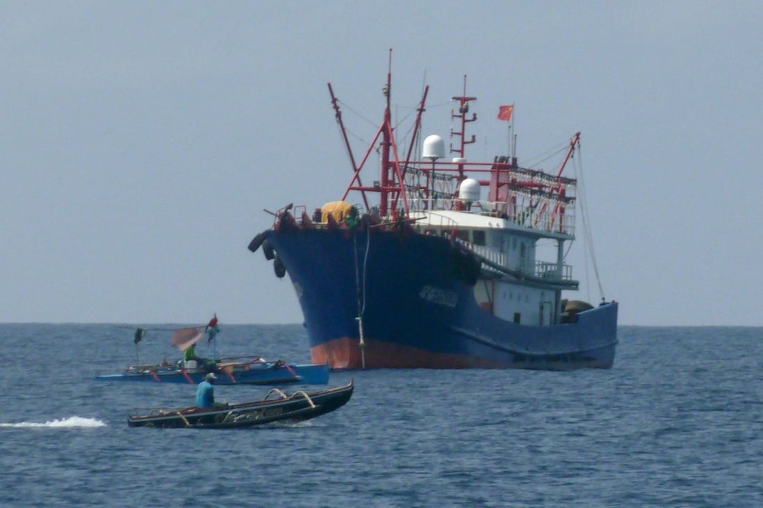 Filipino fishermen aboard their boats sail past a Chinese vessel near the Scarborough Shoal in the disputed South China Sea, on February 6. Rising regional and global tensions threaten to thwart Indonesia’s efforts to revive negotiations over a code of conduct in the South China Sea. Photo: AFP