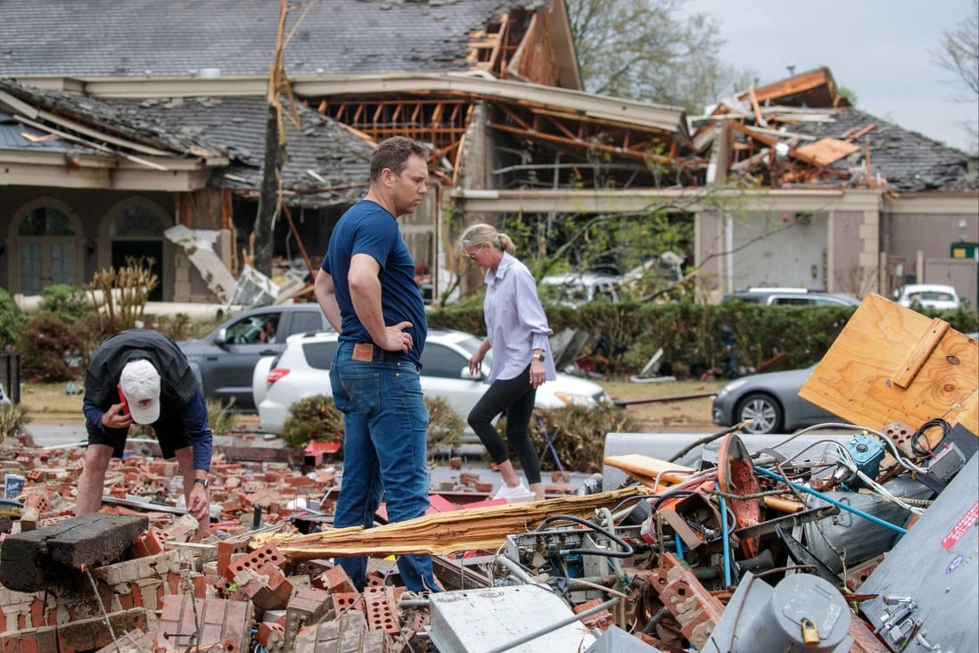 A family search through rubble for belongings after a direct tornado strike to their business in Little Rock, Arkansas.on Friday. Photo: Getty Images North America / AFP