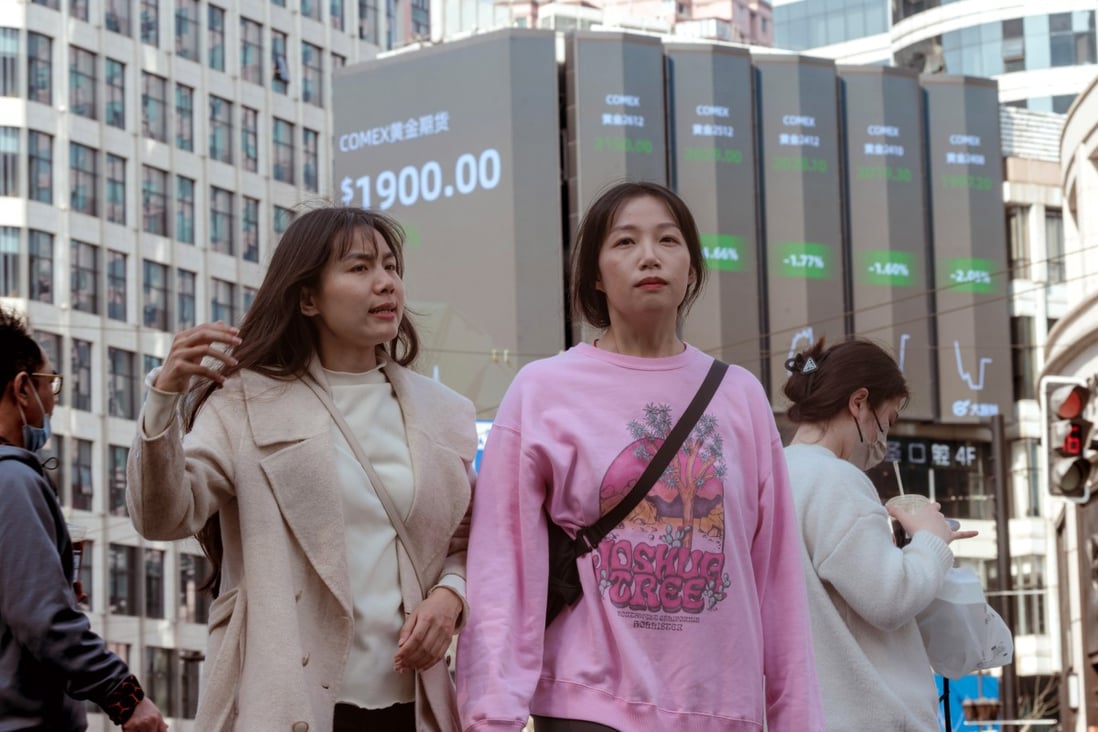 People walk near a large screen showing stock exchange data in Shanghai on March 15, a day after Asia-Pacific markets sank in the fallout from failed US banks. Photo: EPA-EFE